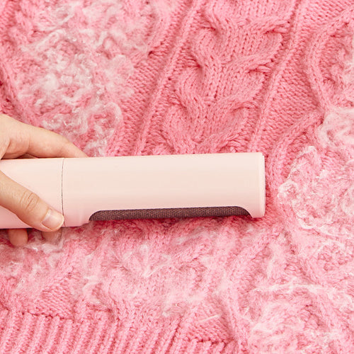 Rolling PawRoll over pink knit fabric to lift pet hair